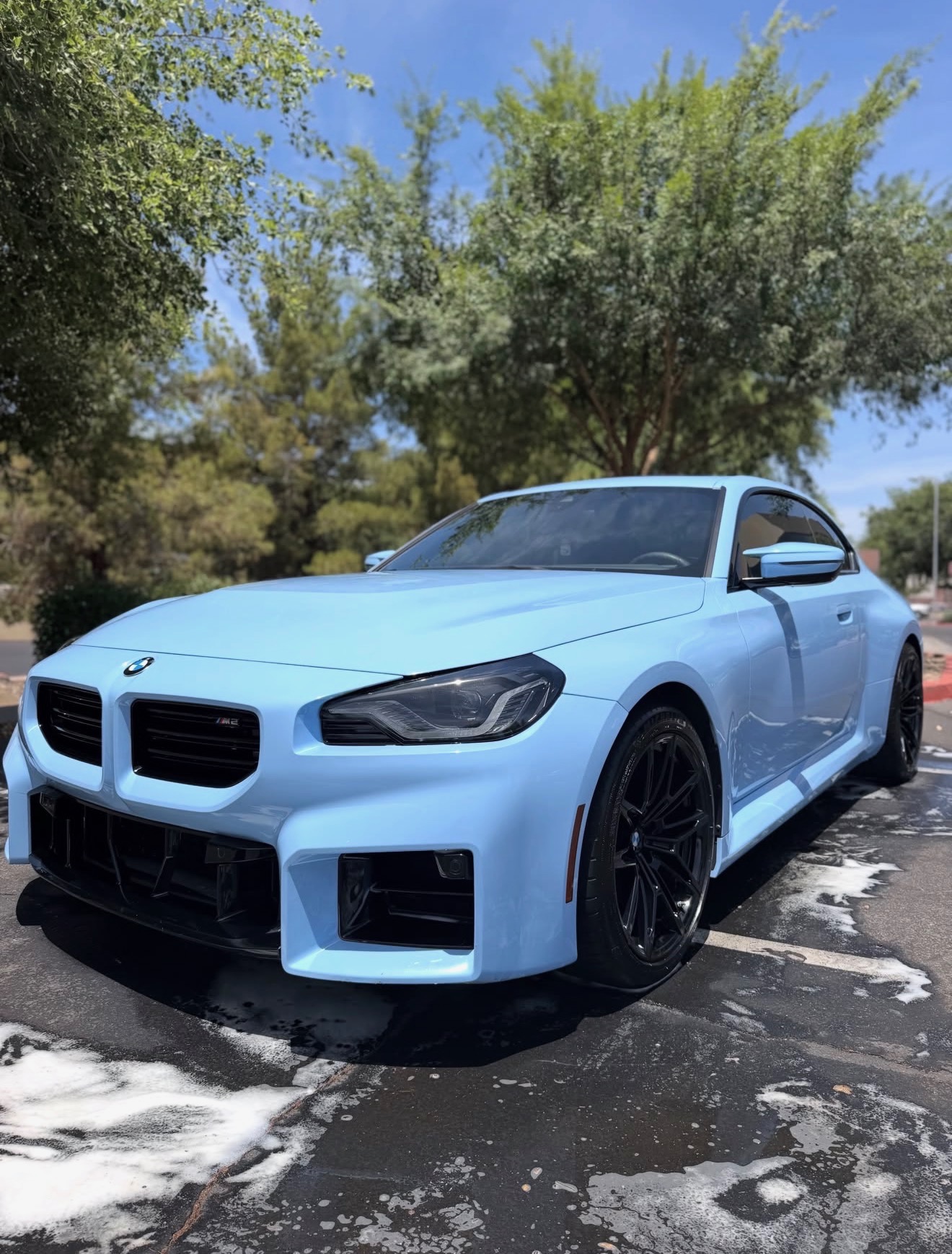 Glossy light blue BMW M2 after an exterior detail