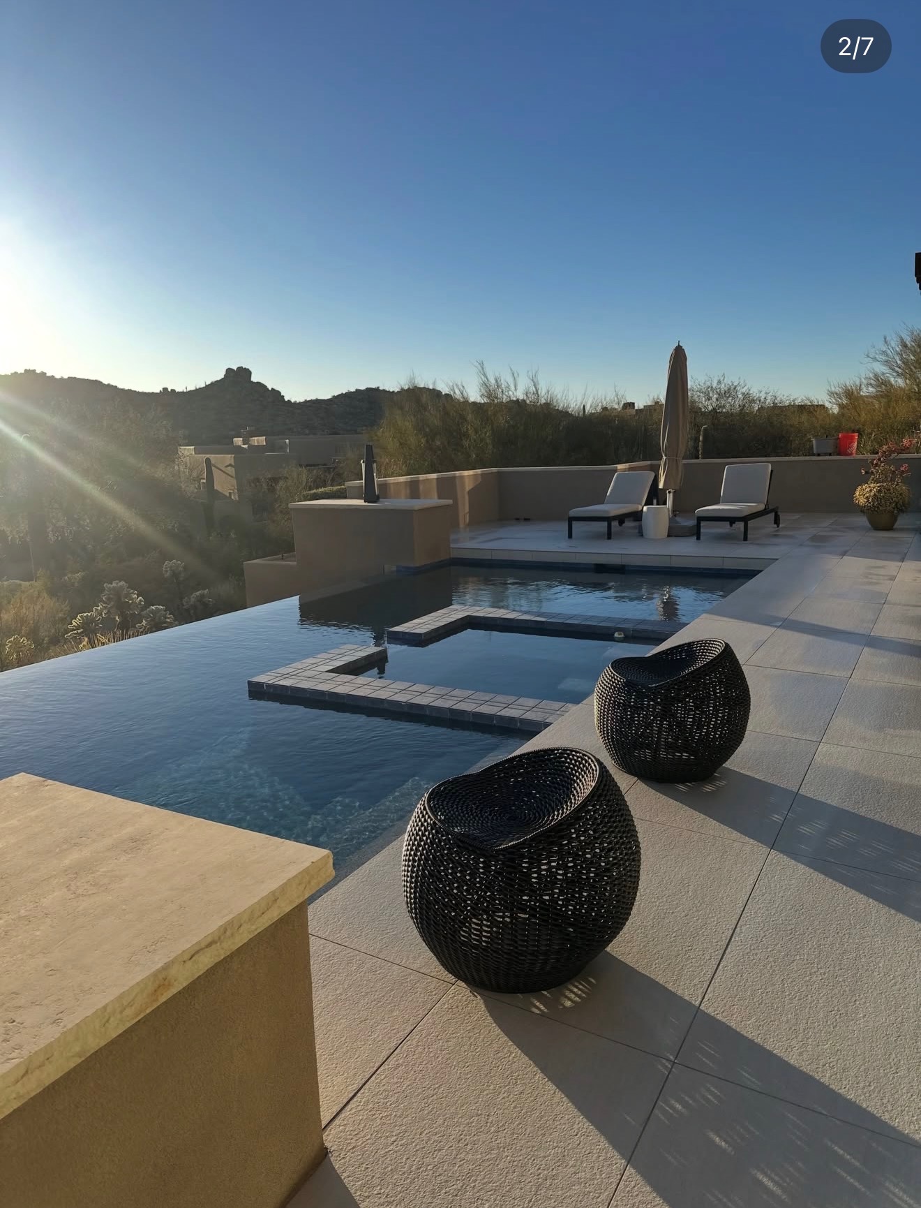 Infinity pool and travertine deck overlooking Arizona desert mountains